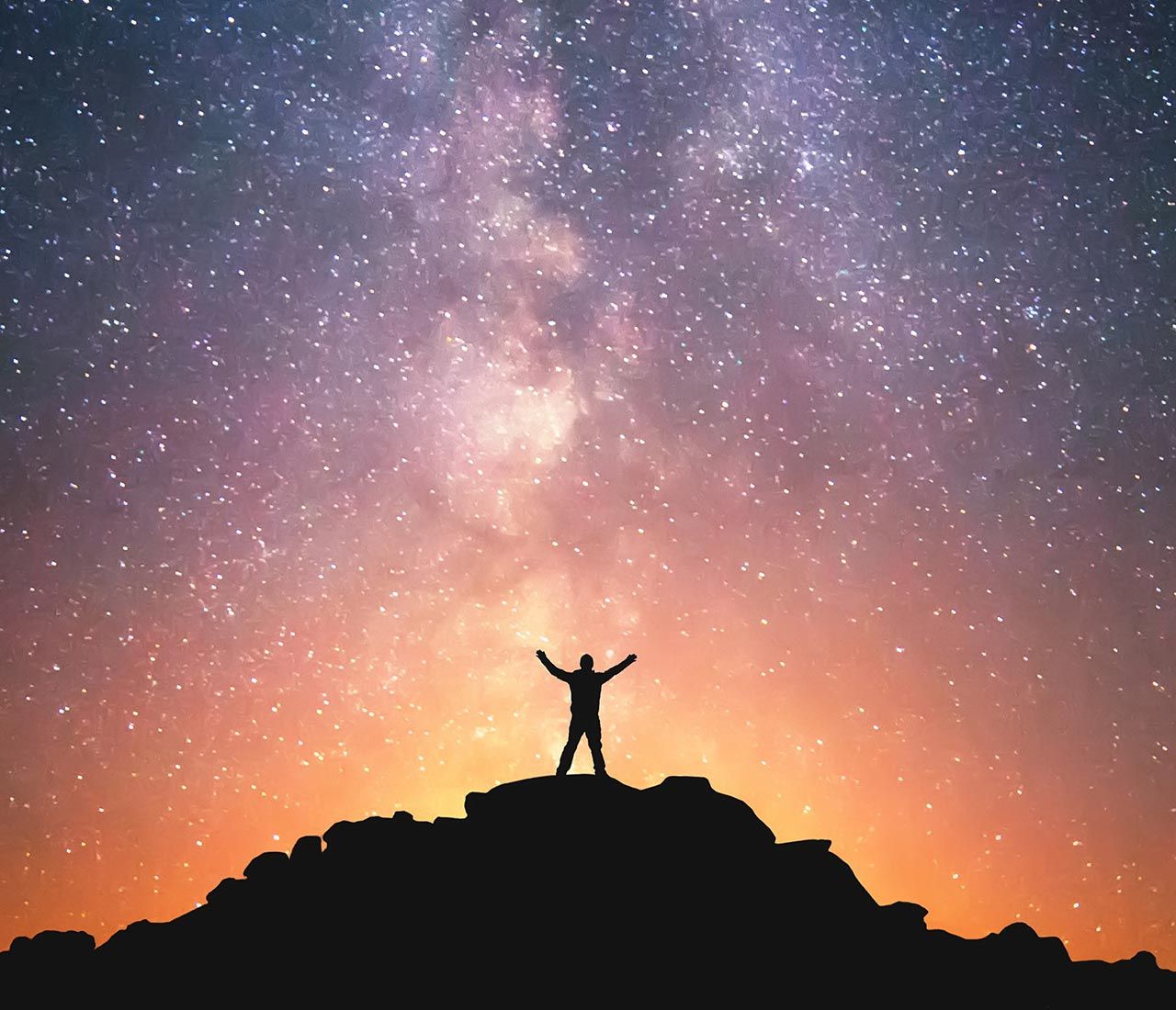 Person steht auf einem Hügel vor einem Sternenhintergrund